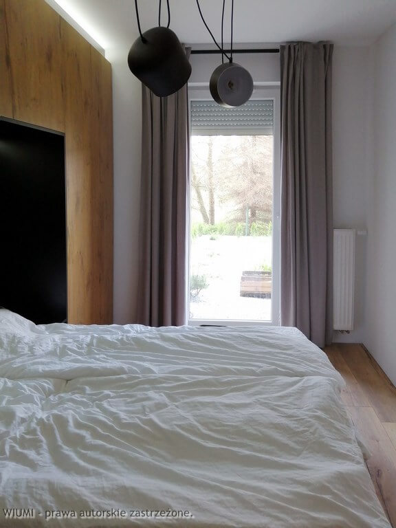 Projektant wnętrz Wrocław pokazuje na fotografii sypialnia z oknem balkonowym