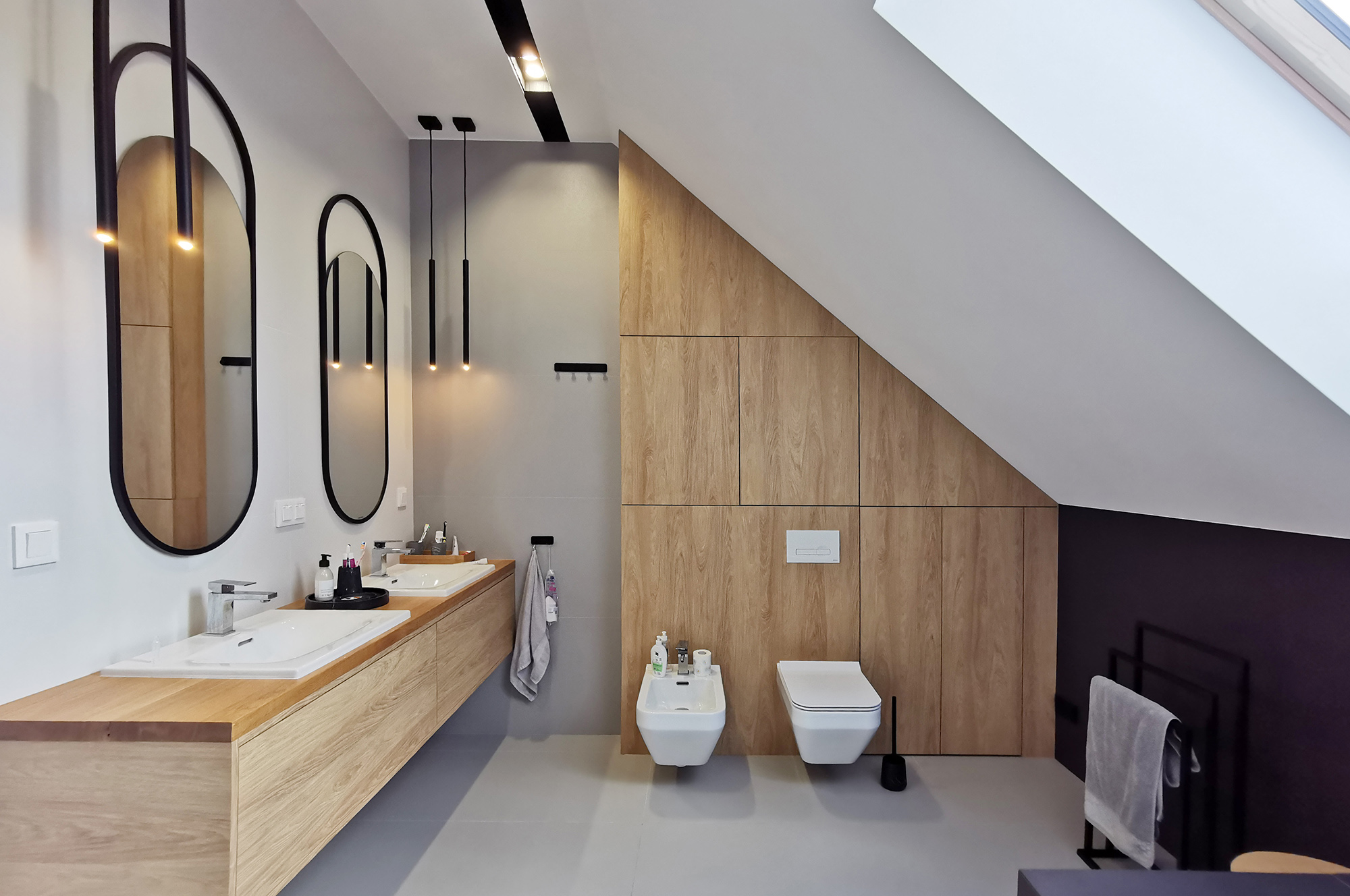 2a Projektowanie wnętrz Wrocław WIUMI przedstawia łazienkę z dwoma lustrami i umywalkami oraz ubikacją i bidetem.