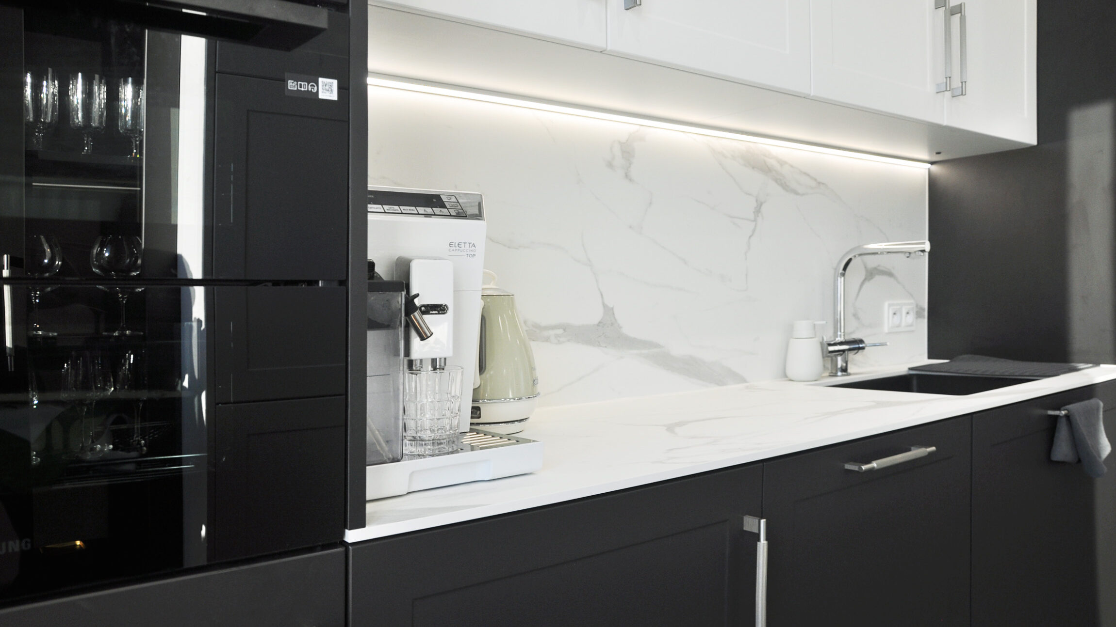 Biuro projektowanie WIUMI przedstawia kuchnię z piekarnikiem i ekspresem do kawy.