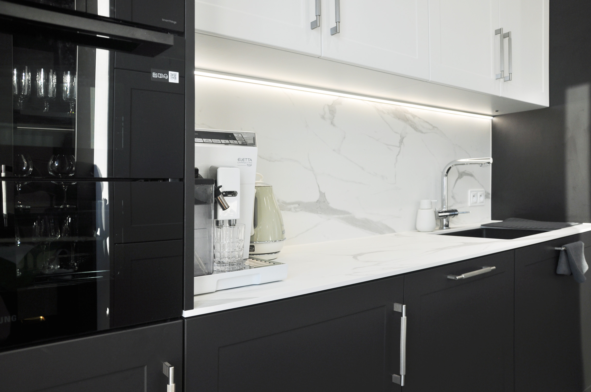 4b Biuro projektowanie WIUMI przedstawia kuchnię z piekarnikiem i ekspresem do kawy.